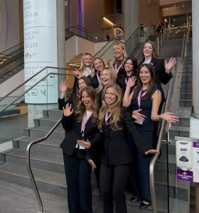 Group of young professionals smiling together in a photo.